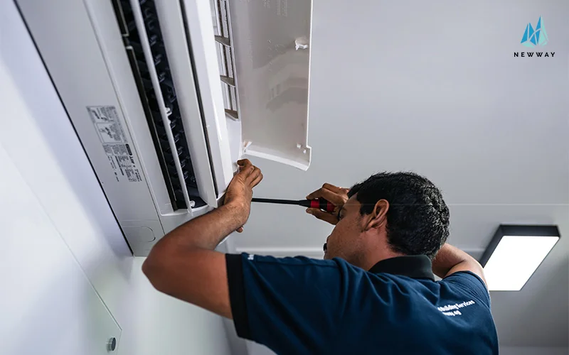Technician repairing an aircon condenser unit.