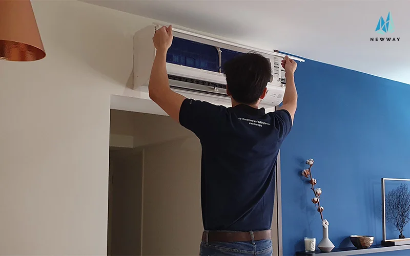 Technician performing aircon condenser unit maintenance