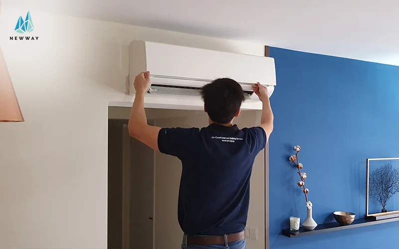A technician installs a wall-mounted air conditioner