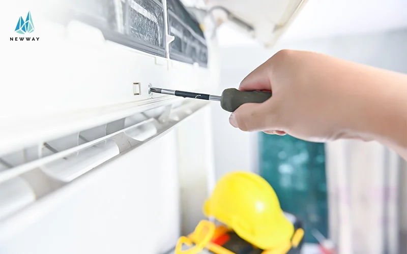 A technician repairs an air conditioning unit