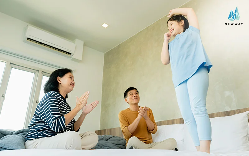 Family enjoying cool air from air conditioner at home