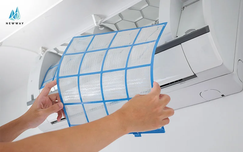 Hands removing air filter from split air conditioner