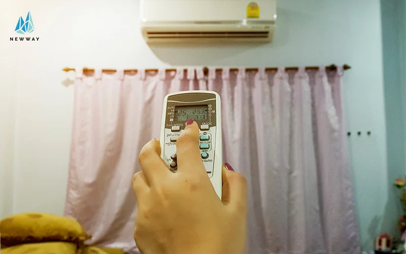 Woman turning on energy efficient climate control air conditioner