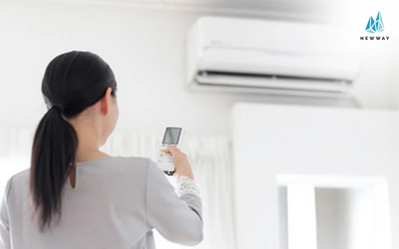 Woman using a remote to turn on the aircon